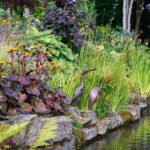 sculpture of birds in garden by a lake