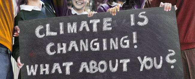 children holding sign saying climate is changing what about you