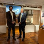Two men standing in a room displaying a dinosaur exhibition