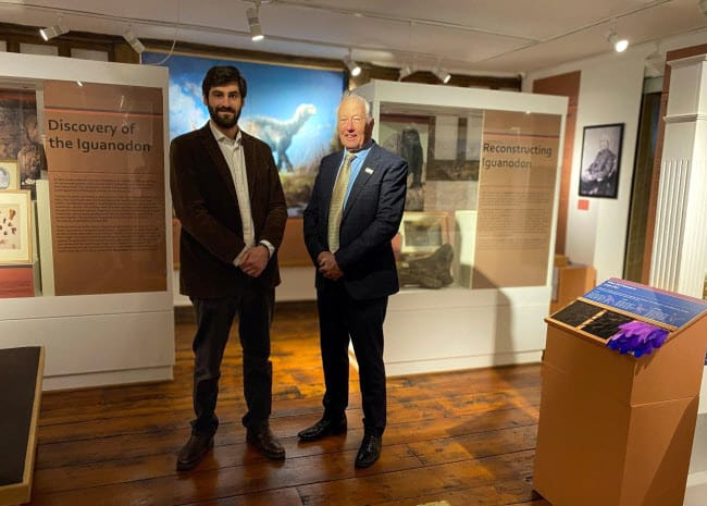 Two men standing in a room displaying a dinosaur exhibition